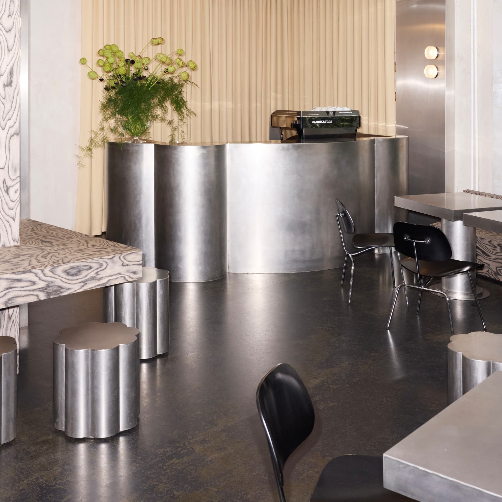 Interior of DRAFT. Zürich with the curved steel counter and cloud-shaped stools